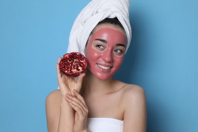 Woman with pomegranate face mask and fresh fruit on light blue background