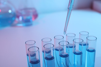 Photo of Dripping reagent into test tube with blue liquid, closeup. Laboratory analysis