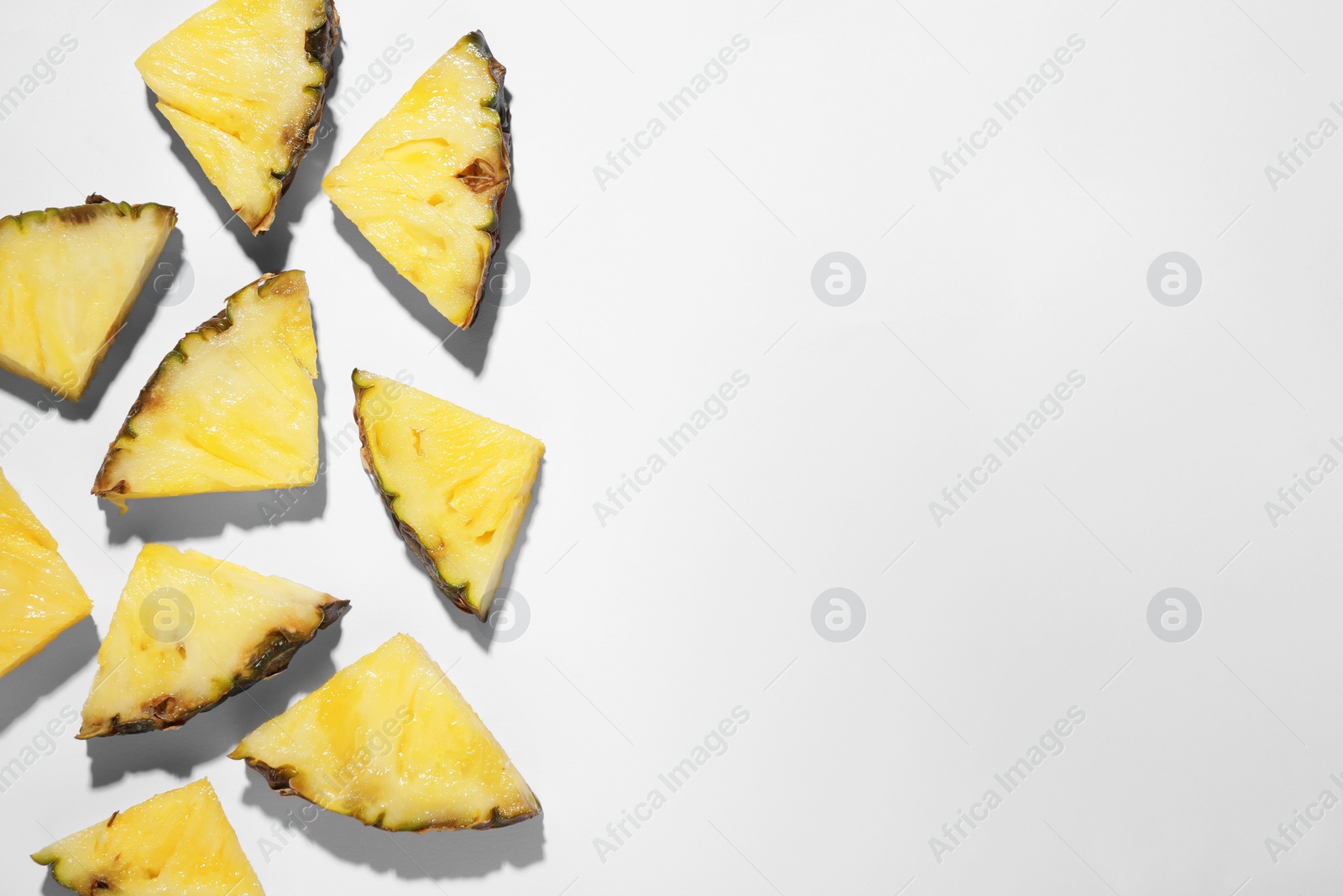 Photo of Pieces of tasty ripe pineapple on white background, flat lay. Space for text