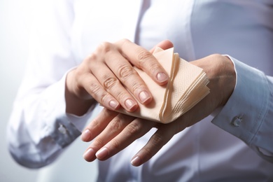 Photo of Woman cleaning hands with paper napkin, closeup