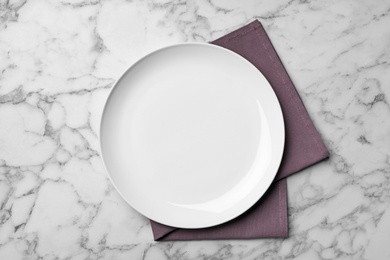 Photo of Stylish ceramic plate and napkin on marble background, flat lay