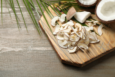Composition with tasty coconut chips on wooden table