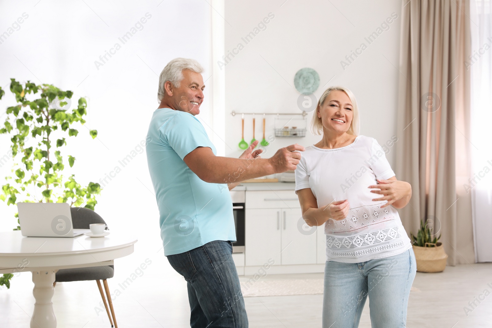 Photo of Happy mature couple dancing together in kitchen