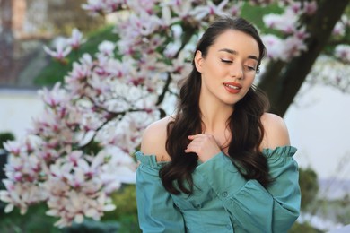 Photo of Beautiful woman near blossoming magnolia tree on spring day