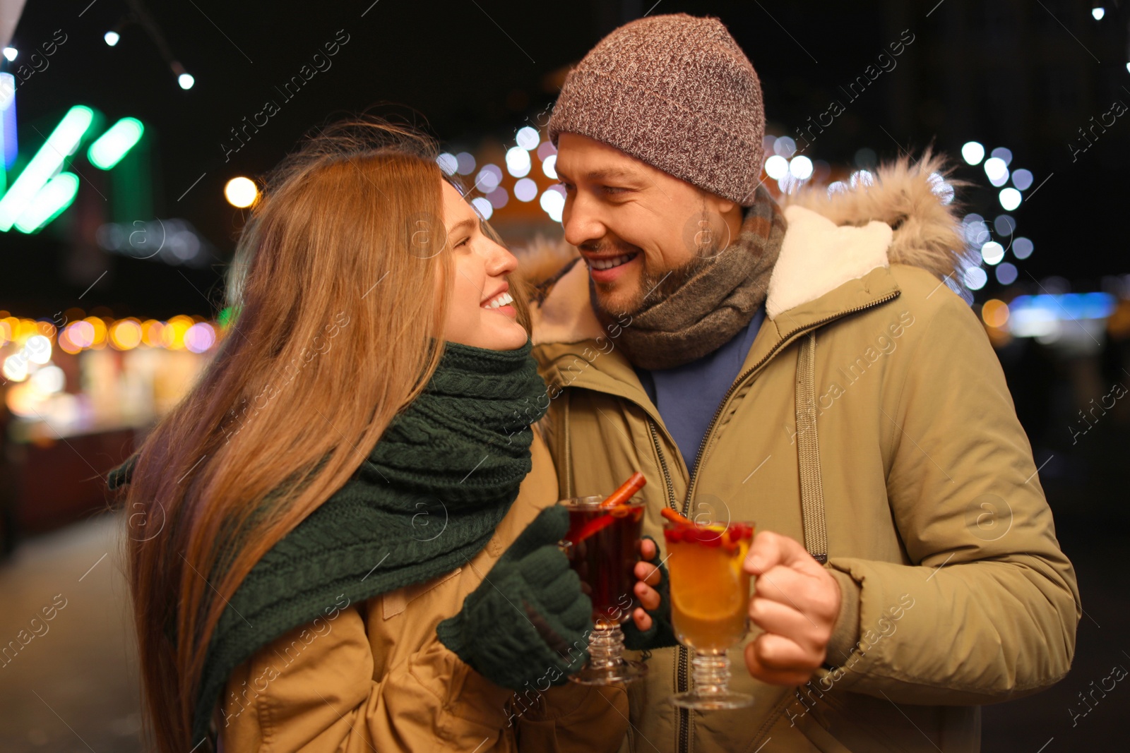 Photo of Happy couple with mulled wine at winter fair