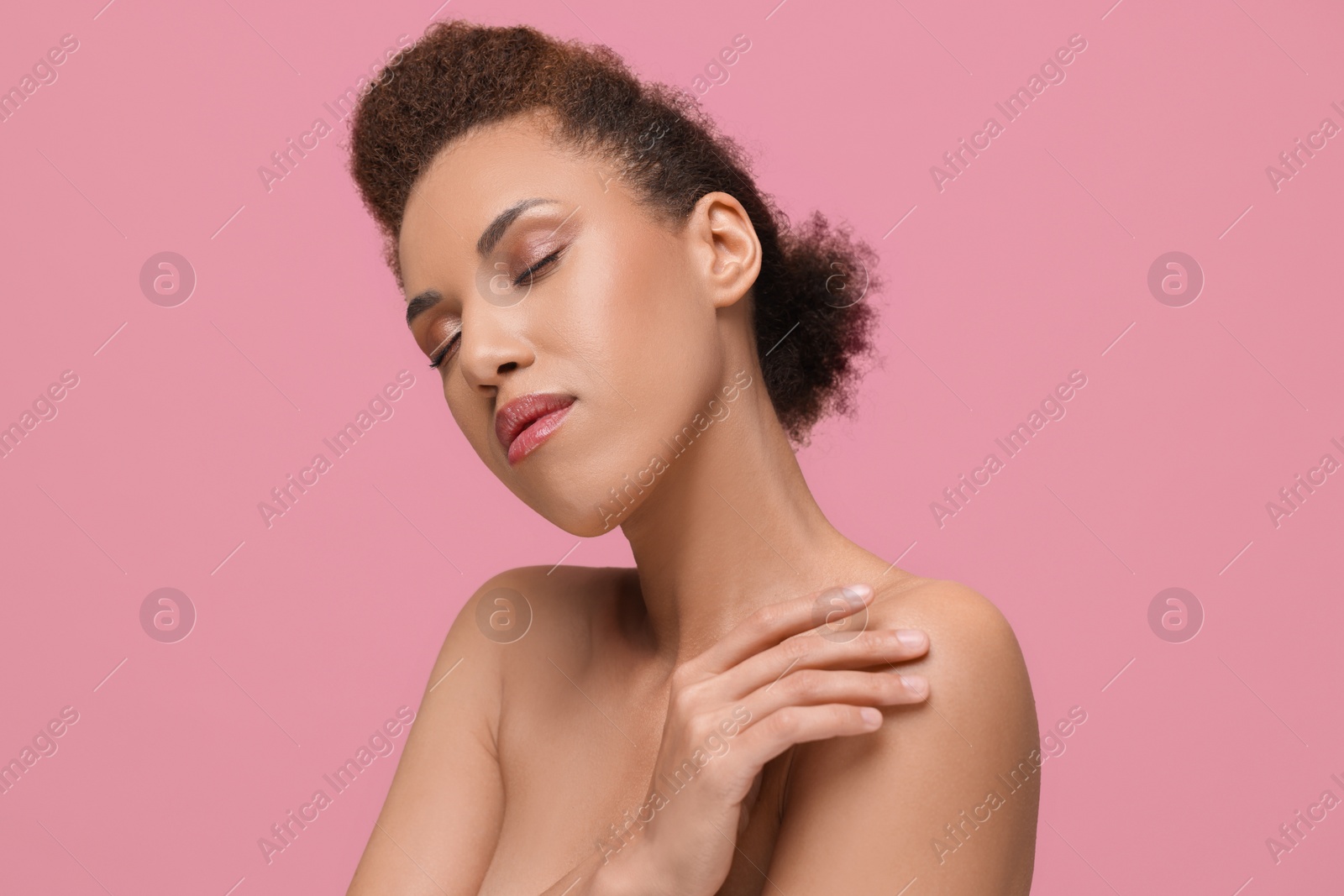 Photo of Portrait of beautiful young woman with glamorous makeup on pink background