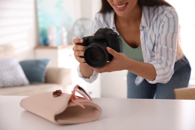 Photo of Young photographer taking picture of accessories indoors, closeup