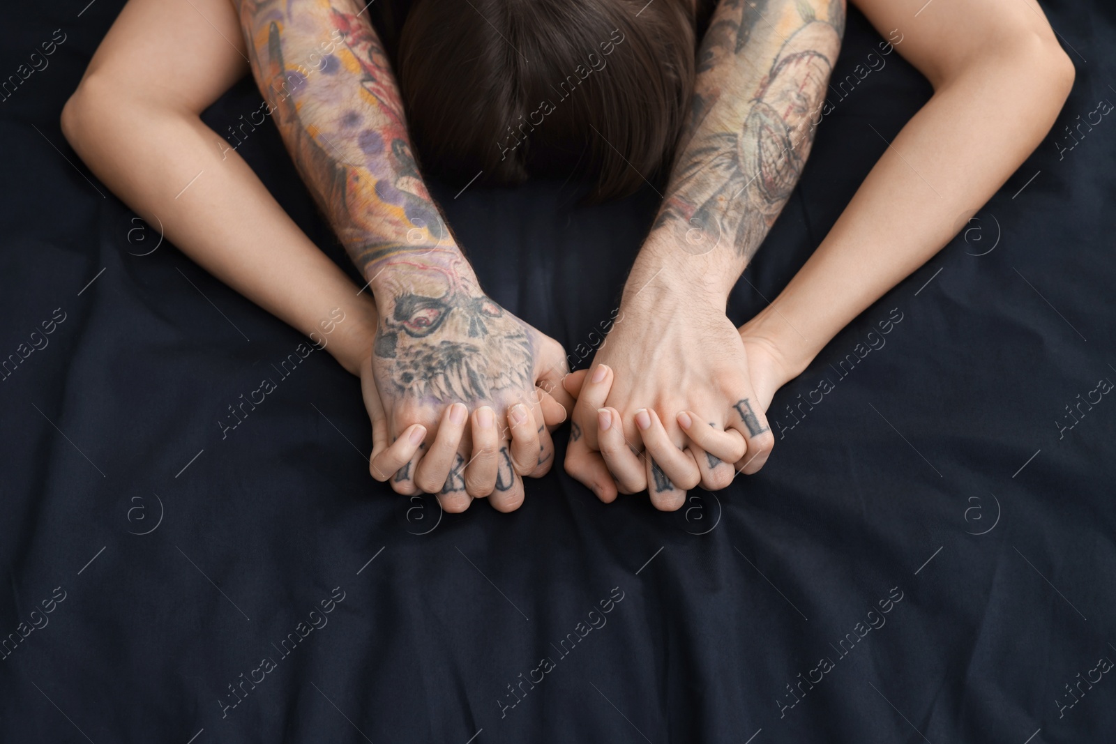 Photo of Passionate couple having sex on bed, closeup of hands