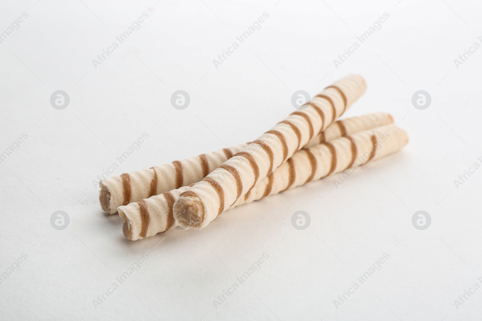 Photo of Delicious wafer rolls on white background. Sweet food