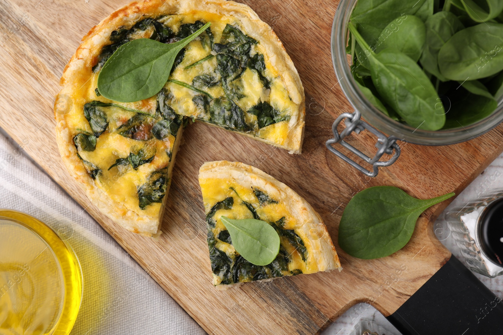 Photo of Delicious cut pie with spinach on table, flat lay