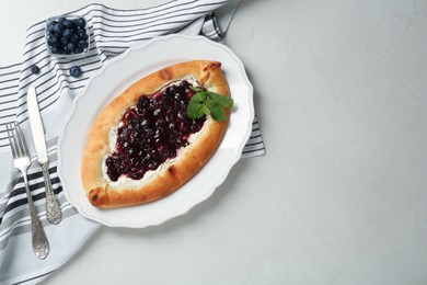 Photo of Delicious sweet cottage cheese pastry with cherry jam served on light table, flat lay. Space for text