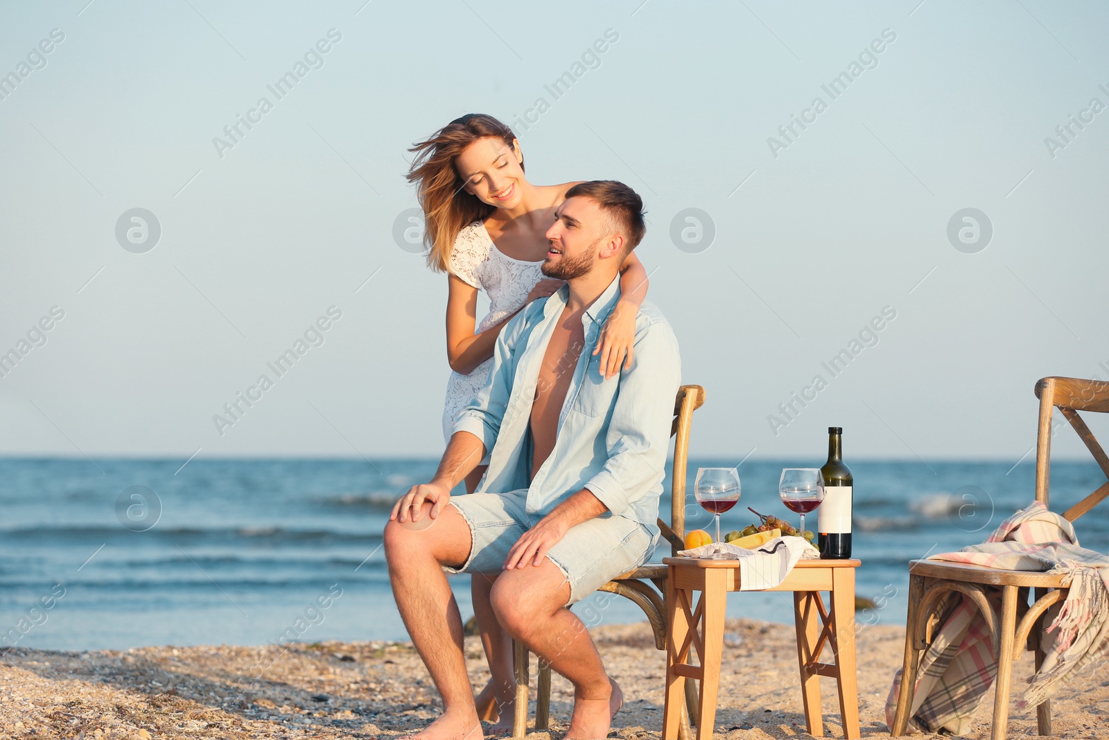 Photo of Happy young couple having romantic dinner on beach