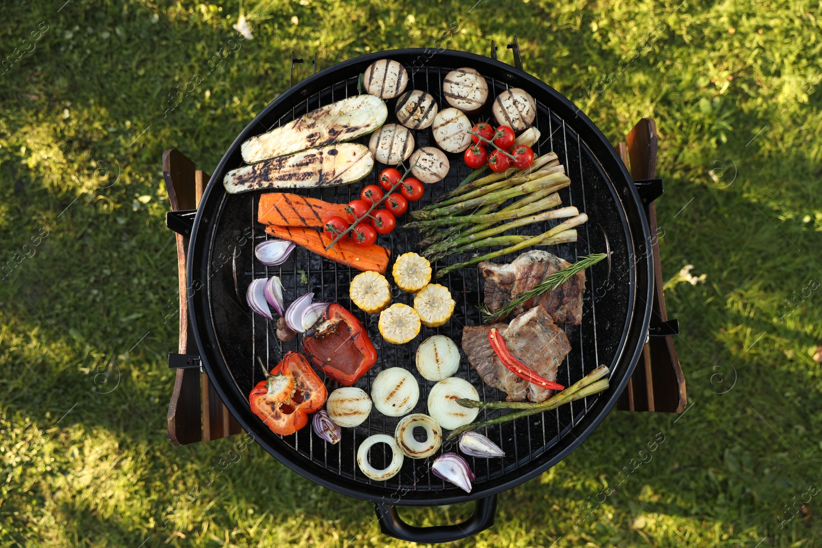 Photo of Delicious grilled vegetables and meat on barbecue grill outdoors, top view