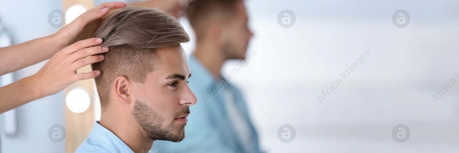 Image of Professional hairdresser working with young man in barbershop. Banner design