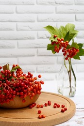 Photo of Composition with ripe red viburnum berries on white wooden table