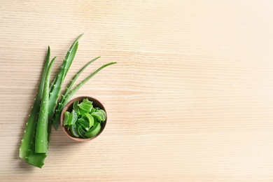 Flat lay composition with aloe vera leaves and space for text on wooden background