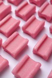 Photo of Tasty pink chewing gums on white background, closeup