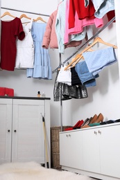 Modern dressing room with different stylish clothes and shoes