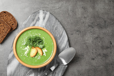 Photo of Tasty kale soup served on grey table, flat lay. Space for text