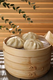 Delicious bao buns (baozi) on wooden table, closeup