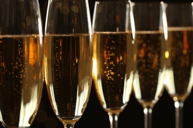 Glasses of champagne on dark background, closeup