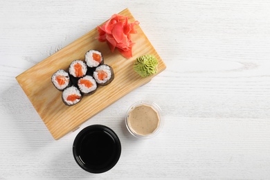 Photo of Flat lay composition with sushi rolls and space for text on white wooden table. Food delivery