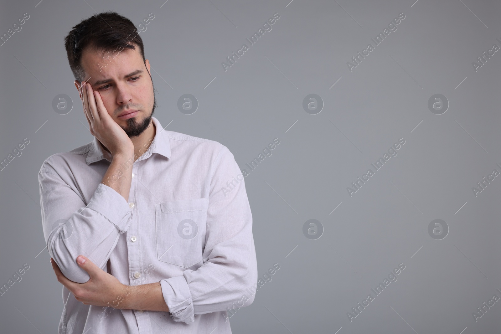 Photo of Portrait of sad man on grey background, space for text