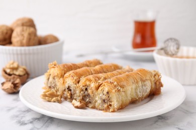 Photo of Eastern sweets. Pieces of tasty baklava on white marble table, closeup