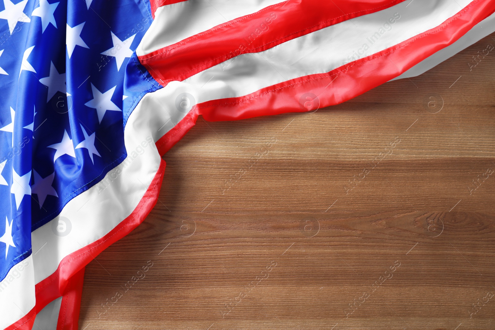 Photo of American flag on wooden background, top view with space for text. Independence Day