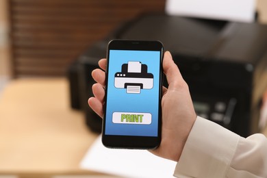 Man using printer management application on mobile phone indoors, closeup. Image on device screen.