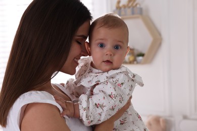 Photo of Happy young mother with her baby daughter at home