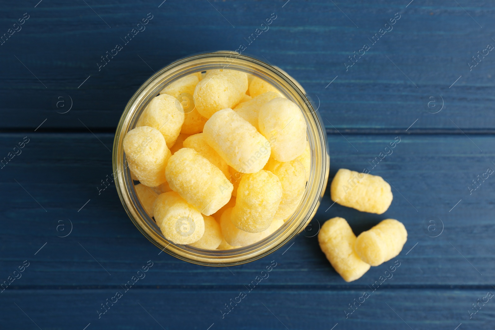 Photo of Delicious crispy corn sticks on blue wooden table, flat lay