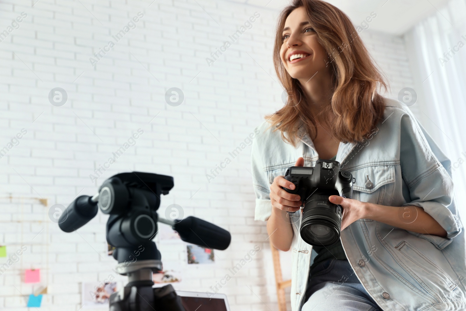 Photo of Professional photographer with camera working in light modern office