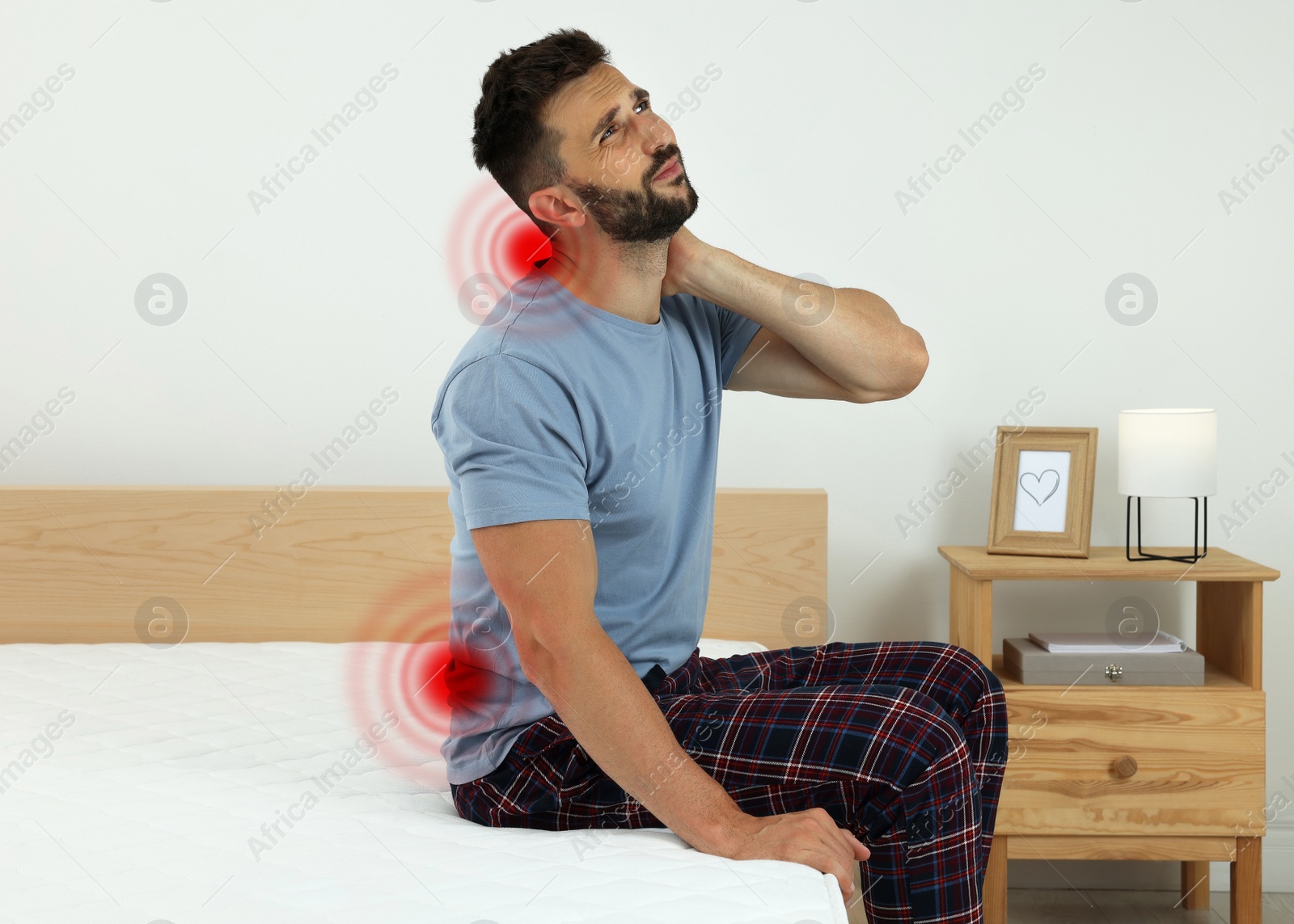 Image of Man suffering from neck pain after sleeping on uncomfortable mattress at home