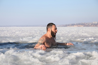 Photo of MYKOLAIV, UKRAINE - JANUARY 06, 2021: Man immersing in icy water on winter day