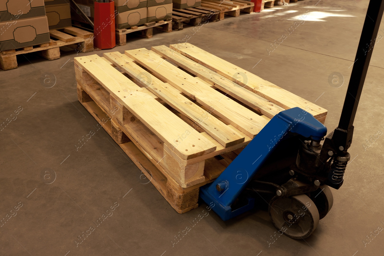 Image of Modern manual forklift with wooden pallets in warehouse