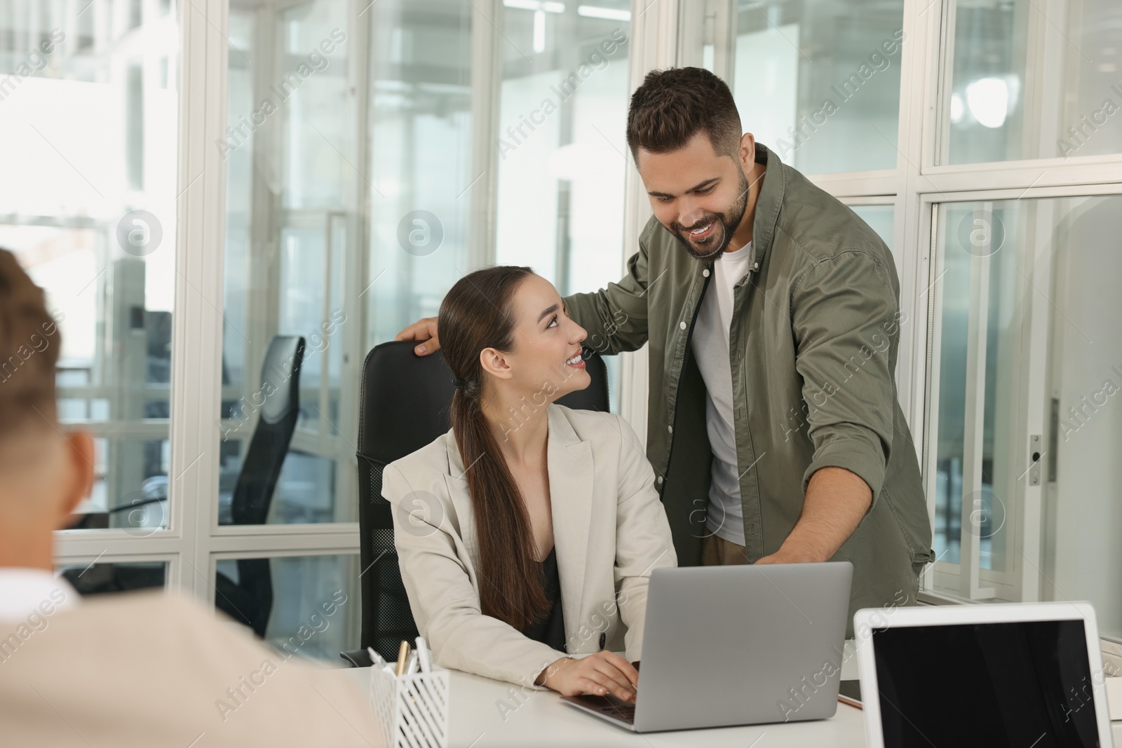 Photo of Colleagues working together in open plan office