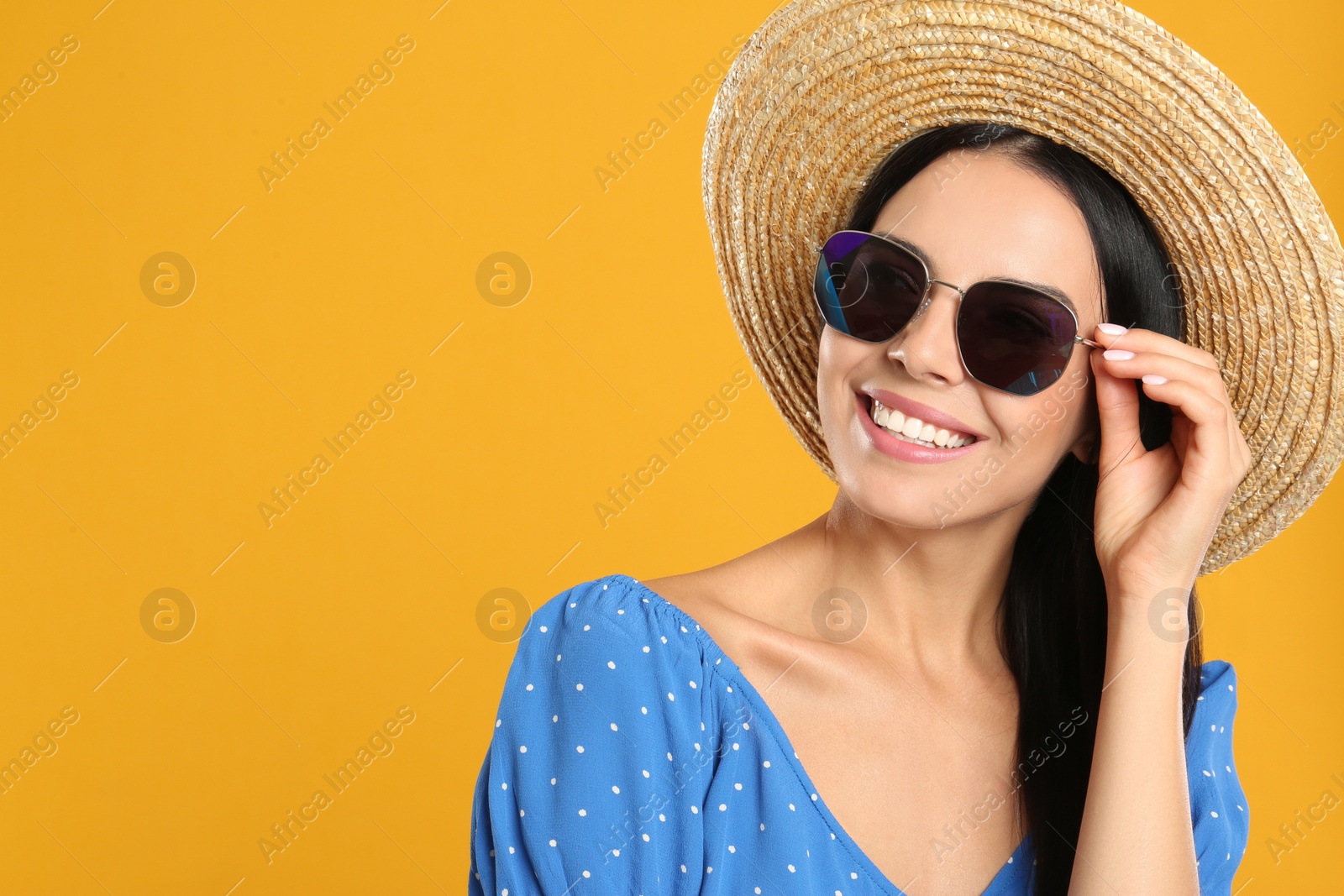 Photo of Beautiful woman wearing sunglasses on yellow background. Space for text