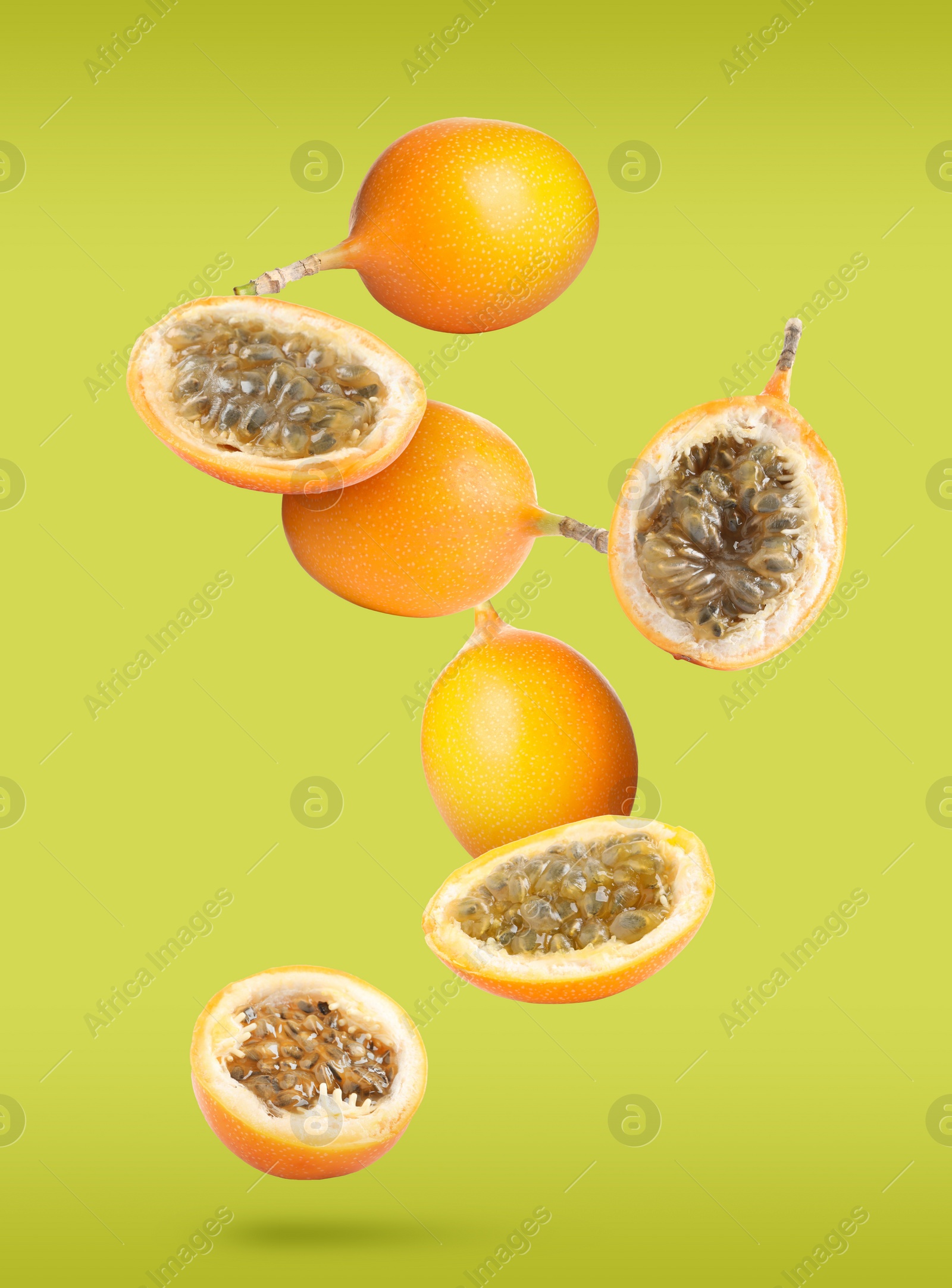 Image of Delicious ripe granadillas falling on yellow green background