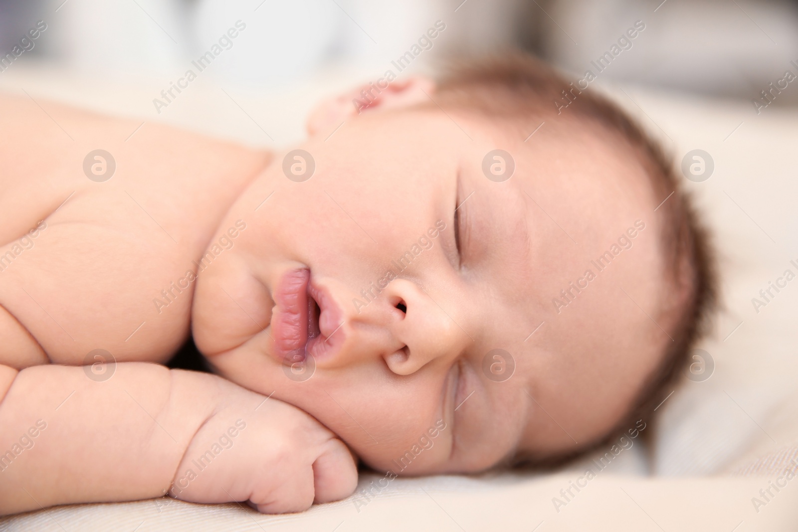 Photo of Adorable newborn baby sleeping on bed, closeup