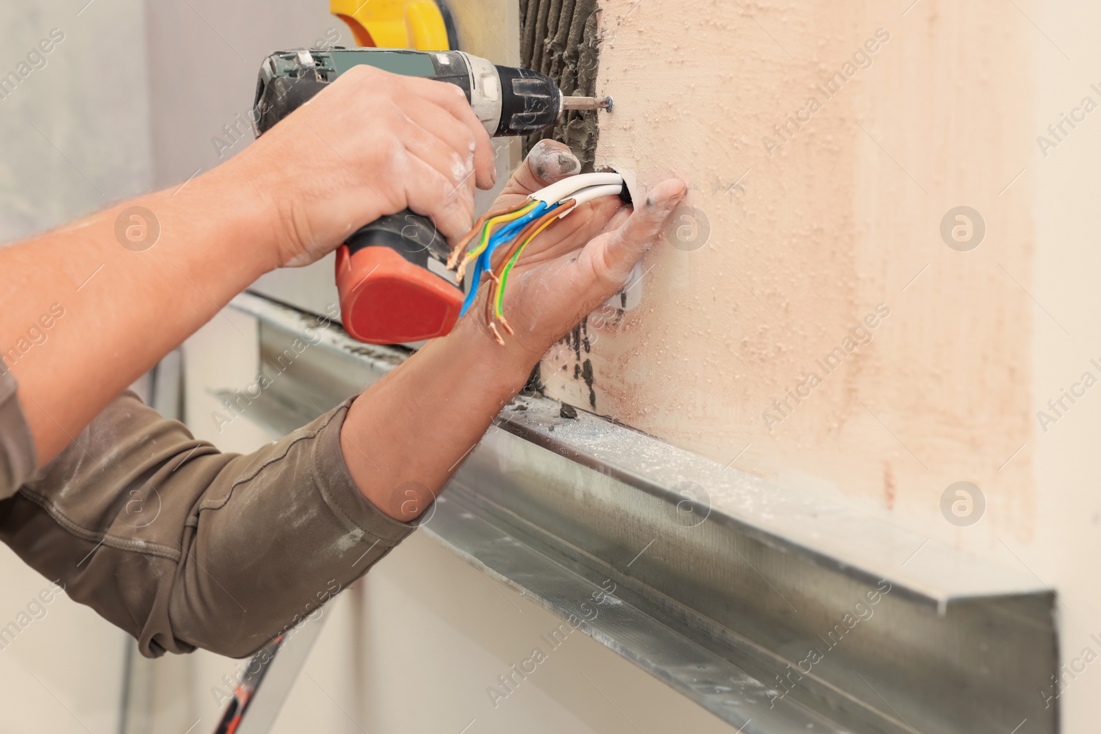 Photo of Worker installing socket in tile indoors, closeup