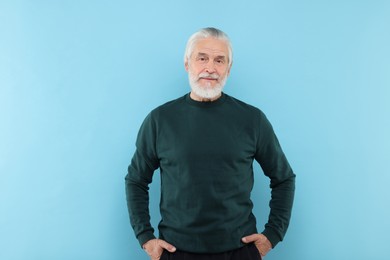 Portrait of handsome senior man on light blue background