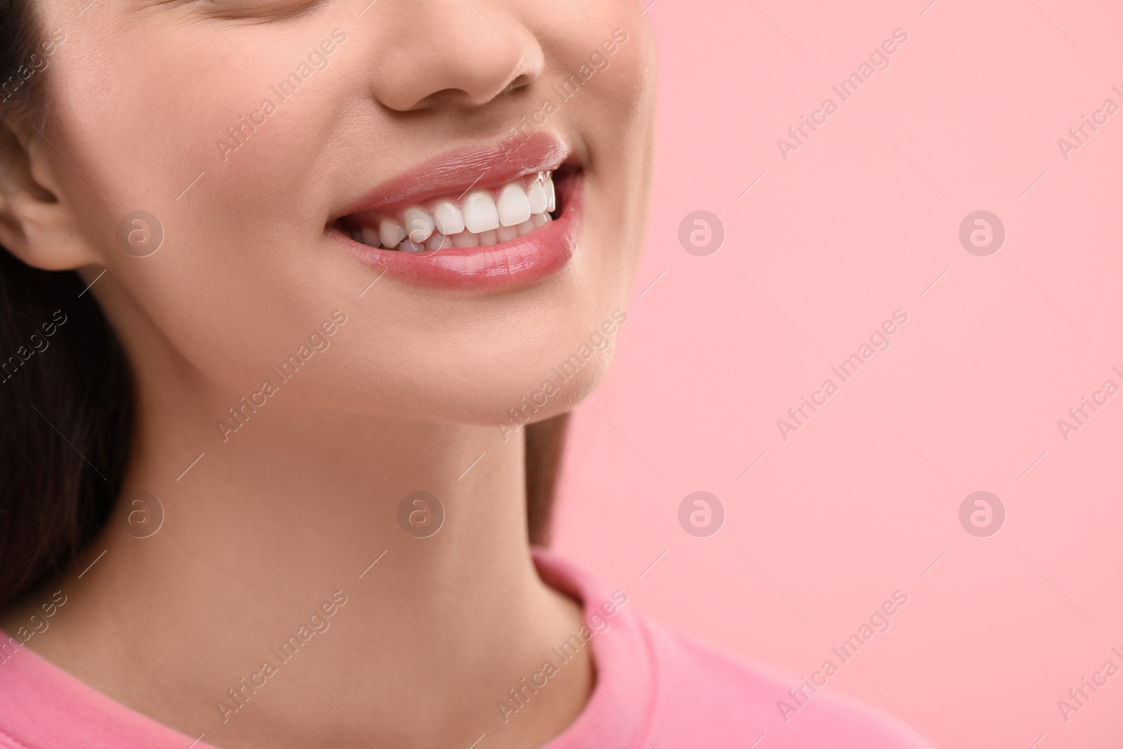 Photo of Woman with clean teeth smiling on pink background, closeup. Space for text