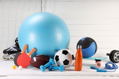 Many different sports equipment on white table