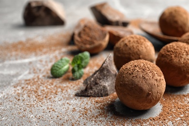 Delicious raw chocolate truffles on grey background, space for text