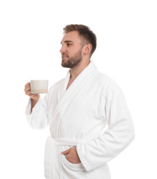 Photo of Handsome man in bathrobe with cup of coffee on white background