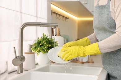 Photo of Housewife washing plate in kitchen sink, closeup