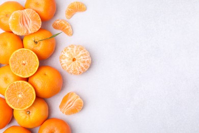 Photo of Fresh juicy tangerines on light grey table, flat lay. Space for text