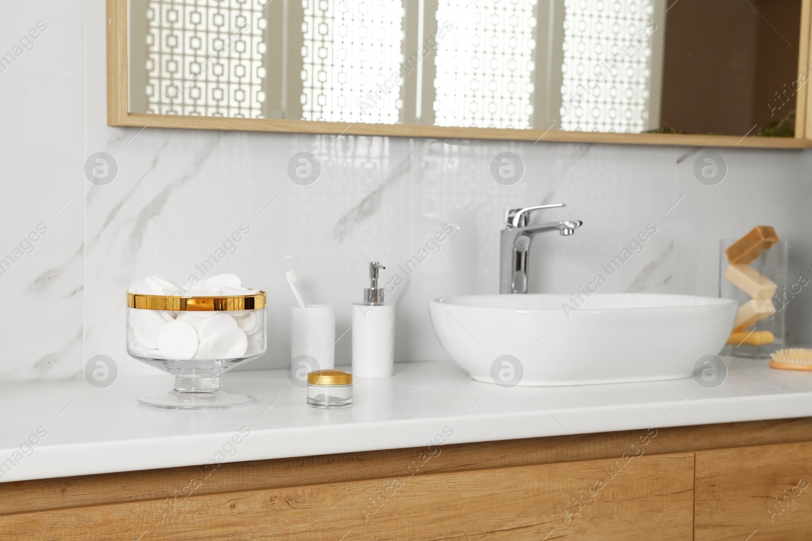 Photo of Jar with cotton pads on bathroom countertop