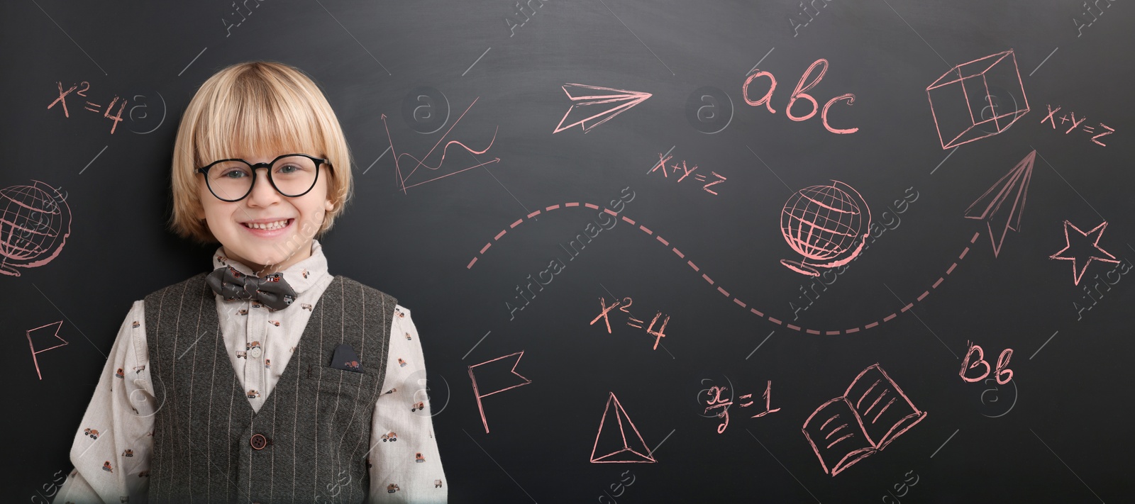 Image of School boy near blackboard with chalk drawings and inscriptions, banner design